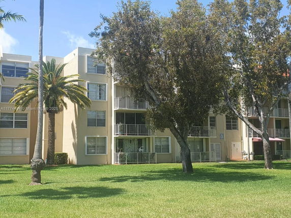 Front view of a multi-story apartment building with balconies.
