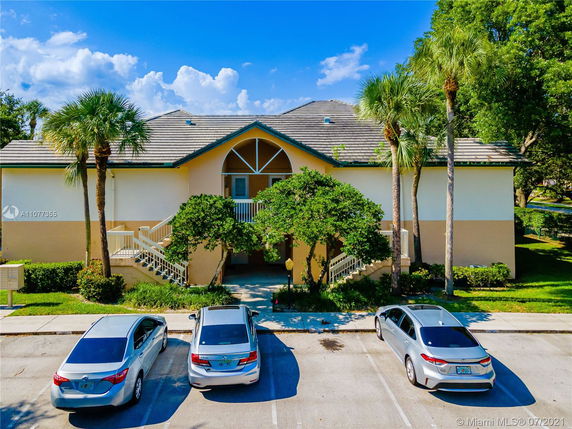 Front view of a two-story building with a gabled roof and exterior stairs leading to the upper level entrance.