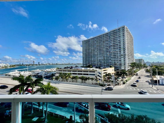 Panoramic view of a marina and tall building from a balcony.