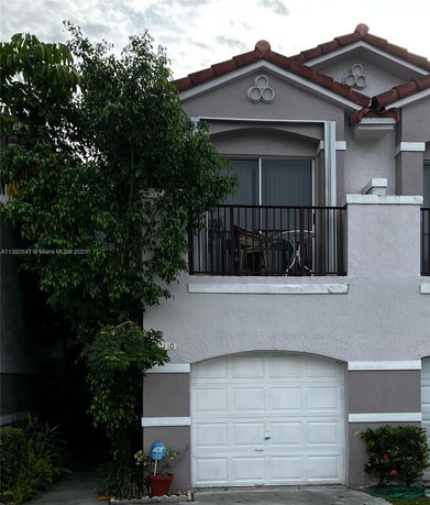 Front view of a multi-story house with a garage and balcony.