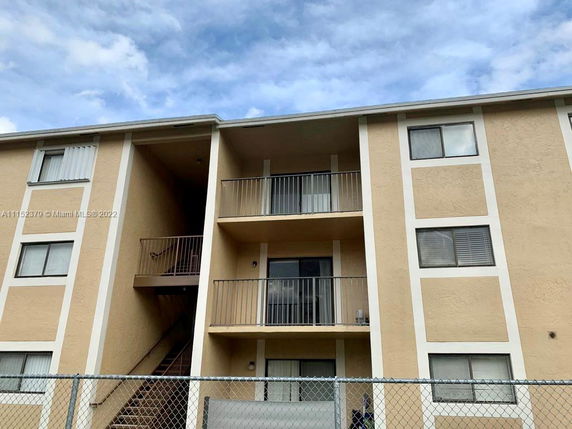 Front view of a multi-story apartment building with balconies.