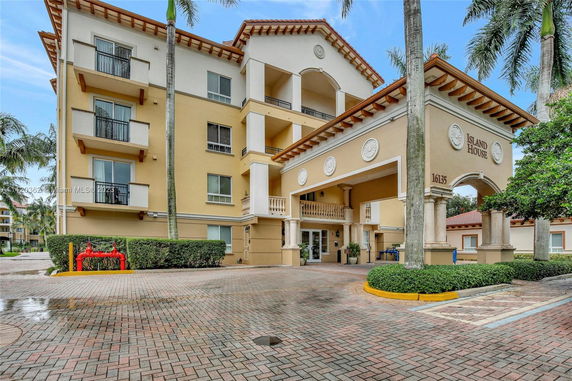 Front view of a multi-story residential building with balconies and columns.