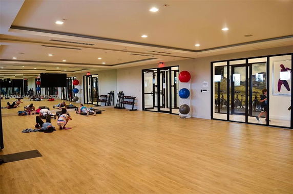 Interior view of a fitness room with exercise equipment and mirrors.