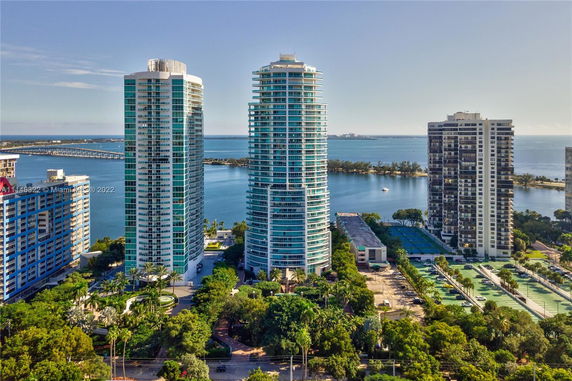 Aerial view of high-rise buildings with a waterfront in the background.