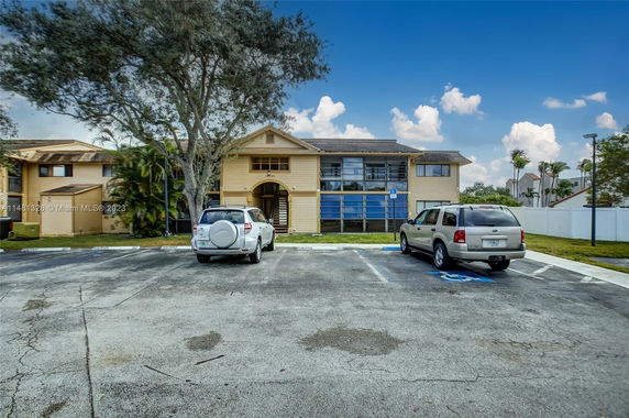 Front view of a two-story building with parking spaces in front.