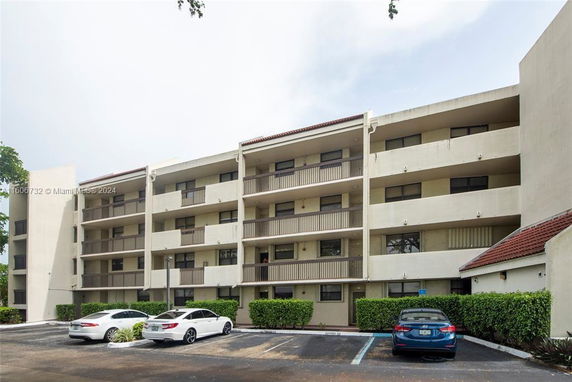 Front view of a multi-story apartment building with balconies.