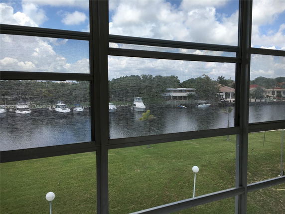 View of a waterfront area with boats and houses as seen from inside a building.