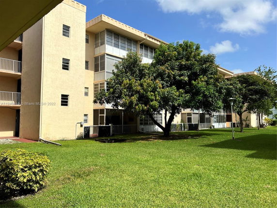 Front view of a multi-story building with balconies and large windows.
