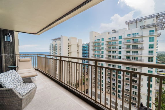 View of high-rise buildings from a balcony with outdoor seating.