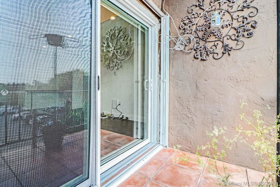 View of a sliding glass door with intricate wall decor on an exterior stucco wall.
