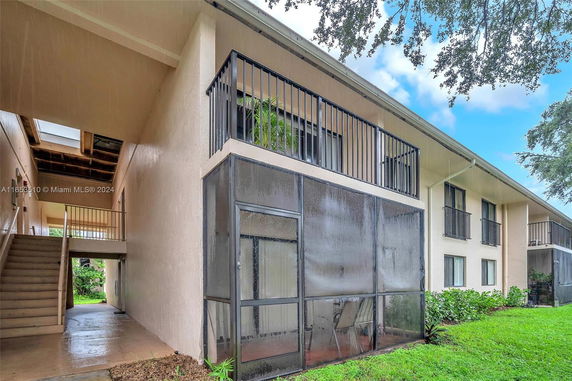 Side view of a two-story building with balconies and screened patios.