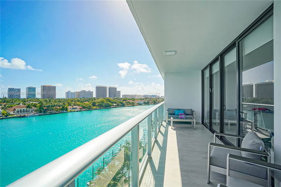 Panoramic view from a balcony showing water and distant buildings.