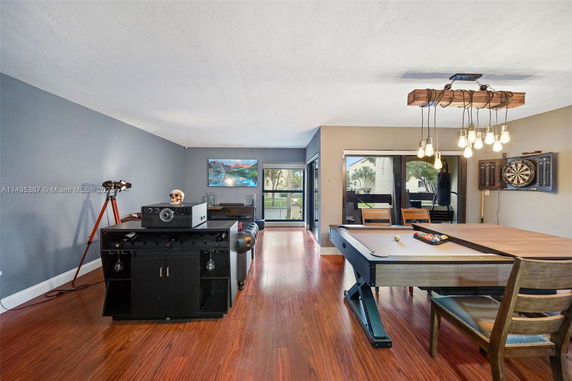 Indoor recreation area with a pool table, dartboard, and seating.
