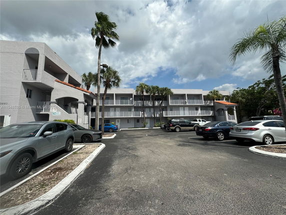 Outdoor parking area in front of a multi-story residential building.