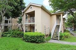 Front view of a two-story residential building with a staircase and balcony.