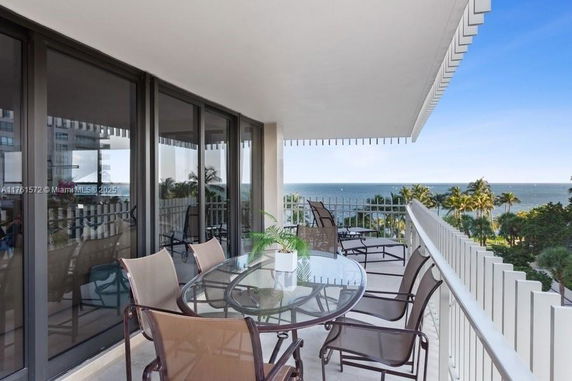 Outdoor balcony view with ocean in the background.