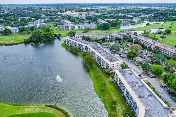 Aerial view of a residential complex surrounded by water bodies and greenery.