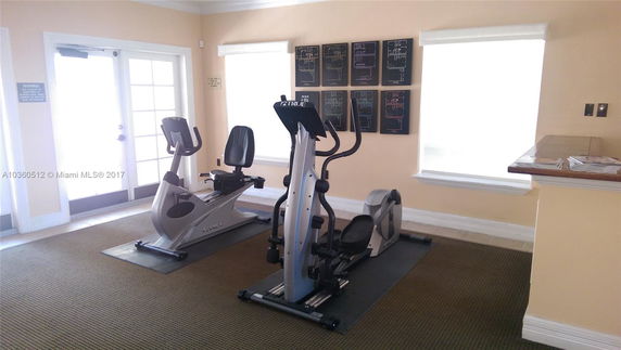 Indoor gym area with exercise machines and a countertop.