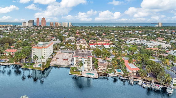 Panoramic view of a neighborhood with high-rise buildings and waterfront properties, visible with ocean in the background.