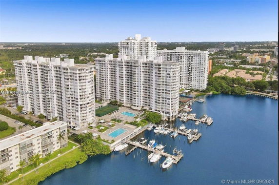 Aerial view of a waterfront complex with multiple high-rise residential buildings and a marina.