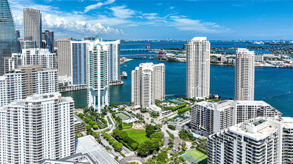 Aerial view of high-rise buildings overlooking a body of water and a distant horizon.