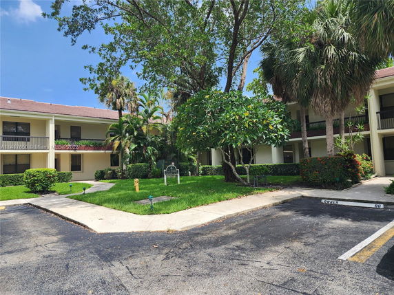 Outdoor view of a residential building with parking space in front.