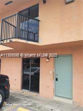Front view of a building with a balcony and door entrance.