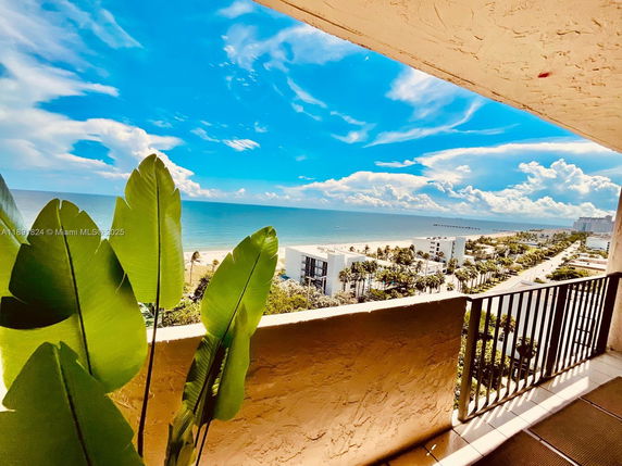 Panoramic view overlooking the ocean and beachfront properties from a balcony.