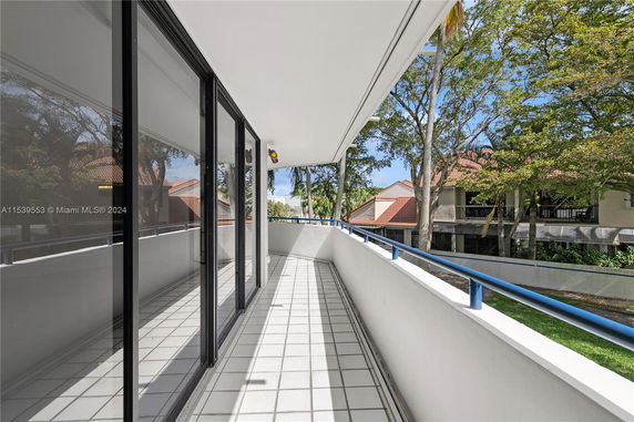 View of a balcony area with adjacent buildings and trees.