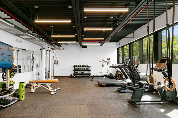 Indoor gym facility with various exercise equipment and weights.