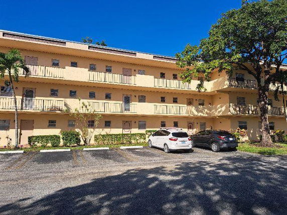 Front view of a three-story apartment building with balconies.
