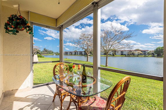 View from a patio overlooking a lake with apartments in the distance.