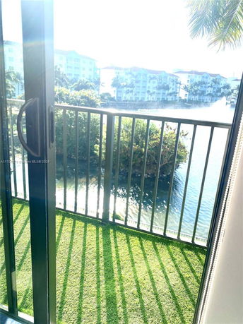 View of surrounding area from a balcony overlooking water and nearby buildings.