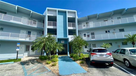 Front view of a multi-story building with balconies and a central entrance.