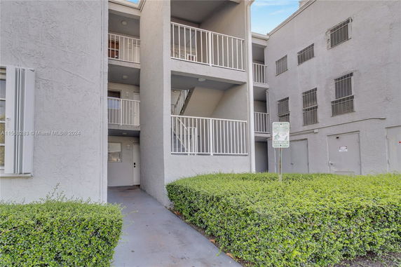 Front view of a multi-story building with balconies and staircases.