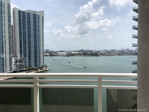 View of high-rise buildings and waterfront seen from a balcony.