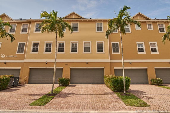 Front view of a multi-story townhouse with multiple garage doors.