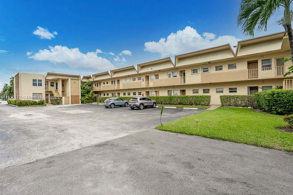 Outdoor parking area in front of a multi-story residential building.