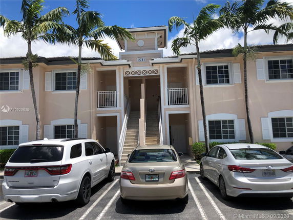 Front view of a two-story building with stair access and parking area.