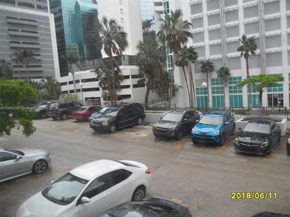 View of multiple multi-story buildings with parking area in front.