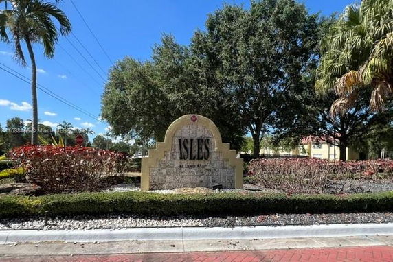 Entrance sign for a residential community named Isles, surrounded by landscaped greenery.