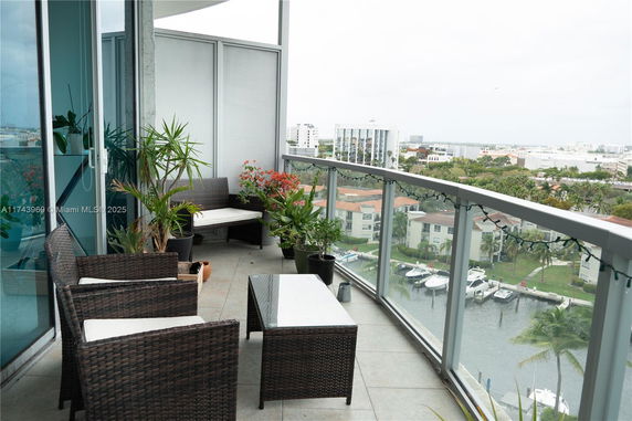 Balcony view from a high-rise building looking out over other buildings and a waterway.