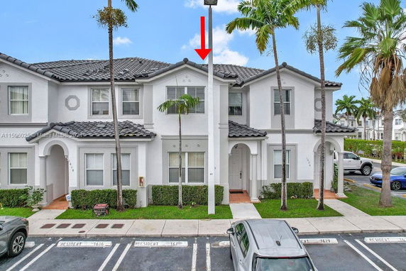 Front view of a two-story townhouse with a tiled roof and two main entrances.