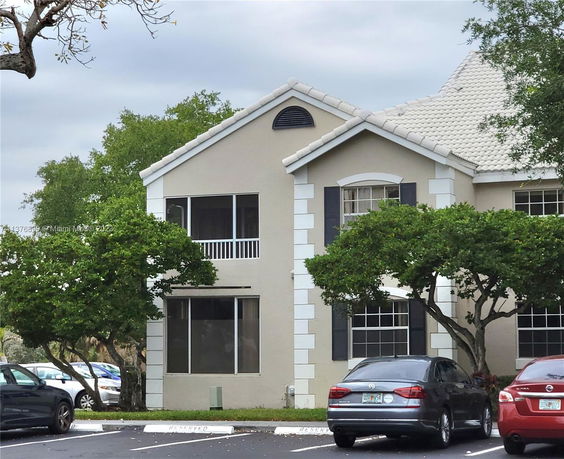 Front view of a two-story house with large windows and a sloped roof.