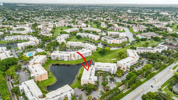 Aerial view of a residential complex with multiple buildings and water features.