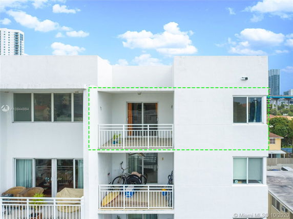 Front view of a multi-story apartment building with balconies.