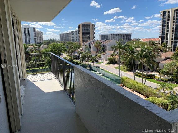 View from a balcony overlooking several multi-story buildings and greenery.