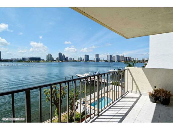 Wide-angle view of a balcony overlooking a body of water and city skyline.
