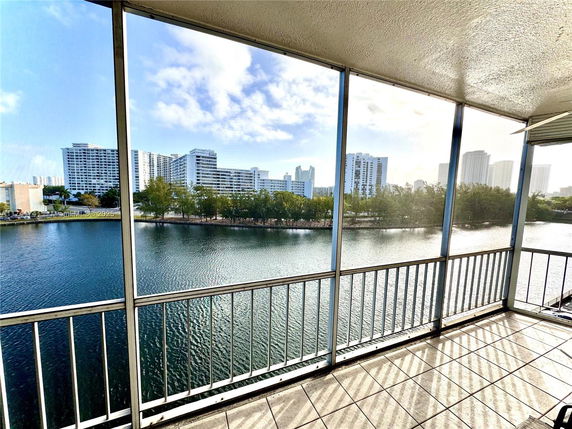 Balcony view overlooking water and distant buildings.