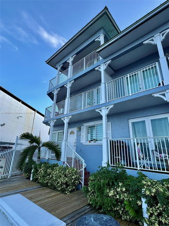 Front view of a three-story building with balconies on each floor.